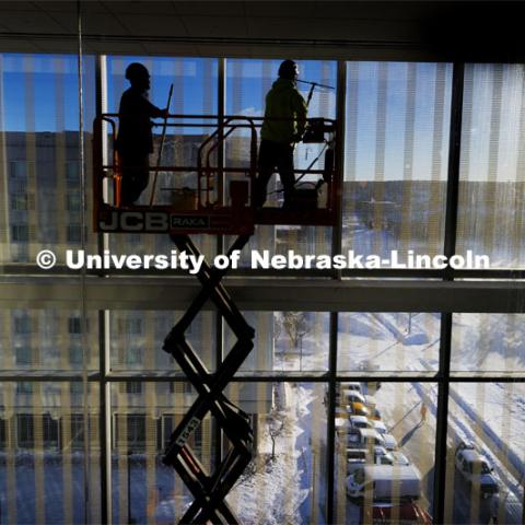 Workers clean the windows in preparation for Kiewit Hall opening Monday, January 22. January 16, 2024. Photo by Craig Chandler / University Communication and Marketing.