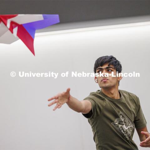 Manas Moondra, a mechanical engineering student, flies a huge paper airplane made by a group of students. The students had 30 minutes to use supplied paper to make their airplanes. Engineering students, staff and faculty finished out the first week of classes in the new Kiewit Hall by having a paper airplane contest in the atrium. Contestants flew three rounds of flights aiming at a bullseye on the first floor. January 26, 2024. Photo by Craig Chandler / University Communication and Marketing.