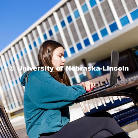 Sophie Perez, freshman in business administration, studies outside Andersen Hall before her Wednesday afternoon sports media communication class. January 31, 2024. Photo by Craig Chandler / University Communication and Marketing.