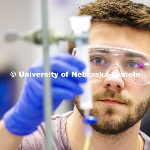 Dillon McClure adds solution to drip through the lab setup to awaiting test tubes. Students isolate and purify lysozyme from actual egg whites in BIOC 401L - Laboratory for Elements of Biochemistry. February 13, 2024. Photo by Craig Chandler / University Communication and Marketing.