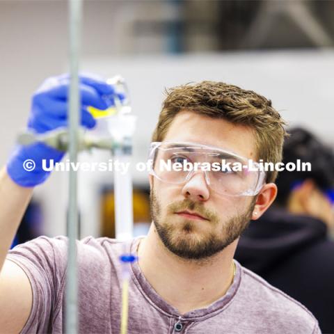 Dillon McClure adds solution to drip through the lab setup to awaiting test tubes. Students isolate and purify lysozyme from actual egg whites in BIOC 401L - Laboratory for Elements of Biochemistry. February 13, 2024. Photo by Craig Chandler / University Communication and Marketing.