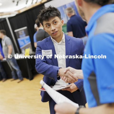 Francisco Becerra, a junior in construction management, talks with a representative from ISEC. University Career + Internship Fair in the Nebraska Union. February 15, 2024. Photo by Craig Chandler / University Communication and Marketing.