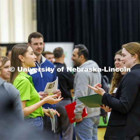 Evie Collier, right, a sophomore in mechanical engineering, talks with Tessa Yackley, a 2023 graduate in Civil Engineering who works for Olsson Engineering and also helps recruit. University Career + Internship Fair in the Nebraska Union. February 15, 2024. Photo by Craig Chandler / University Communication and Marketing.