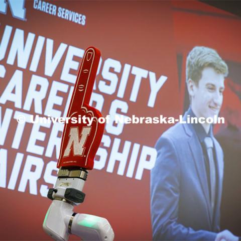 A foam finger on a robotic arm at the Rensenhouse manufacturing booth waves to Huskers. University Career + Internship Fair in the Nebraska Union. February 15, 2024. Photo by Craig Chandler / University Communication and Marketing.