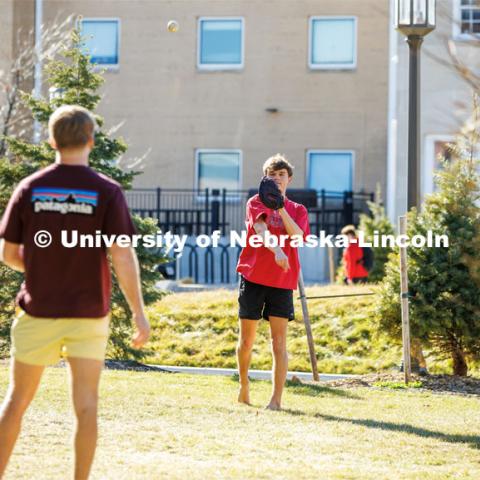 Beta Theta Pi Fraternity brothers play catch in front yard of their Fraternity house. February 20, 2024. Photo by Kristen Labadie / University Communication.