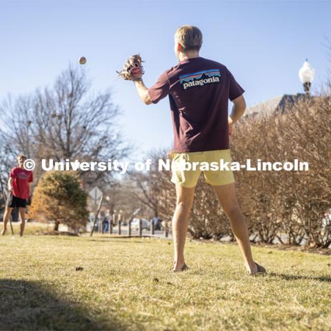 Beta Theta Pi Fraternity brothers play catch in front yard of their Fraternity house. February 20, 2024. Photo by Kristen Labadie / University Communication.