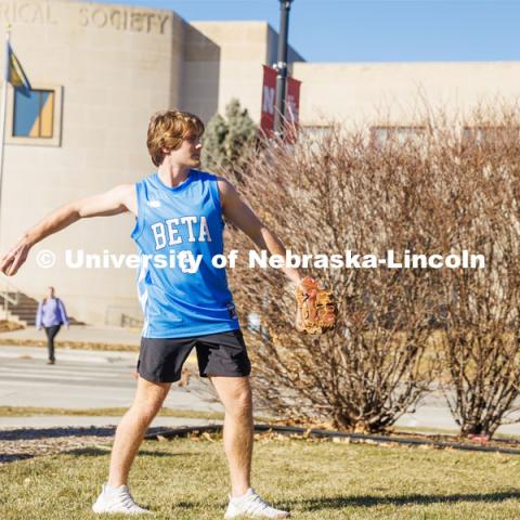 Beta Theta Pi Fraternity brothers play catch in front yard of their Fraternity house. February 20, 2024. Photo by Kristen Labadie / University Communication.