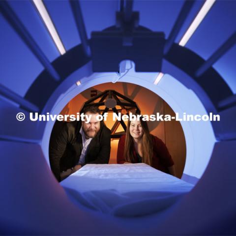 Douglas Schultz (left) and Heather Bouchard peer into the chamber of an MRI machine at the Center for Brain, Biology and Behavior, located within Memorial Stadium. Both from the Department of Psychology and members of CB3 are studying concussions. By working with athletes who recently experienced concussions, the team found that the connections among certain brain regions strengthened even as others weakened — and that these changes correlated with symptoms that often accompany concussions. The findings could help clarify how brain networks respond and reorganize following a concussion. February 21, 2024. Photo by Craig Chandler / University Communication and Marketing.