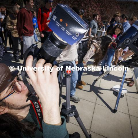 A photographer uses a special lense to photograph the eclipse. The Solar Social party to view the partial solar eclipse filled the greenspace outside the Nebraska Union on City Campus. April 8, 2024. Photo by Craig Chandler / University Communication and Marketing.