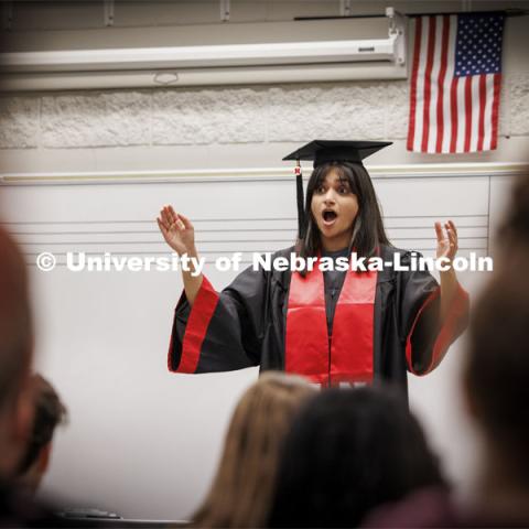 Ananya Amarnath, a May 2024 music education graduate, conducts the Papillion-La Vista South choir as they prepare for their spring performances. Amarnath is shown conducting in her graduation regalia. April 30, 2024. Photo by Craig Chandler / University Communication and Marketing.