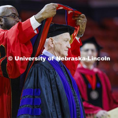 Larry Johnson is hooded by Chancellor Rodney D. Bennett after Johnson has awarded an honorary degree. College of Law commencement in Devaney on the volleyball court. May 3, 2024. Photo by Craig Chandler / University Communication and Marketing.