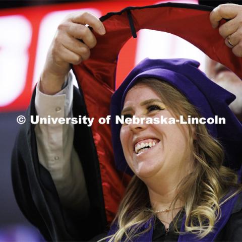 Keali French smiles as she receives her hood. College of Law commencement in Devaney on the volleyball court. May 3, 2024. Photo by Craig Chandler / University Communication and Marketing.