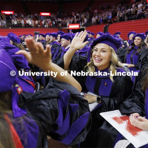 Emma Schlenker high fives her friend Jordyn Piper after they had received their hoods. College of Law commencement in Devaney on the volleyball court. May 3, 2024. Photo by Craig Chandler / University Communication and Marketing.