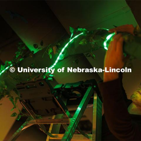 Cooper Watkins adjusts the lights on an archway in the basement hallway of the Carson Emerging Media Arts building. Students are working on their projects in preparation for Friday’s Spring 2024 Open Studios event at the center. May 8, 2024. Photo by Craig Chandler / University Communication and Marketing.