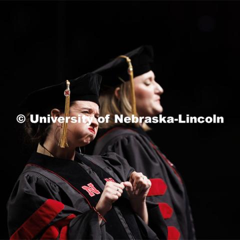 Doctoral candidate Renca Dunn signs the National Anthem while fellow doctoral candidate Rachel Sweeney Green sings. Graduate Commencement. May 17, 2024. Photo by Craig Chandler / University Communication and Marketing.