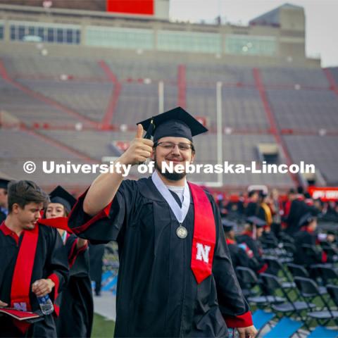 Andrew Voggesser, a Music major, gives a thumbs up to a friend in the crowd. Undergraduate Commencement in Memorial Stadium. May 18, 2024. Photo by Kristen Labadie / University Communication.
