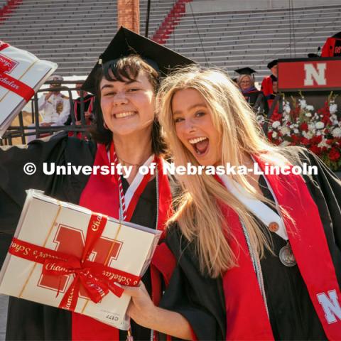 Two Chancellor’s Scholars, Lily Weindel, an Elementary Education major, (left) and Alexandra Johnson, an Advertising and Public Relations major hold up their diplomas. Undergraduate Commencement in Memorial Stadium. May 18, 2024. Photo by Kristen Labadie / University Communication.