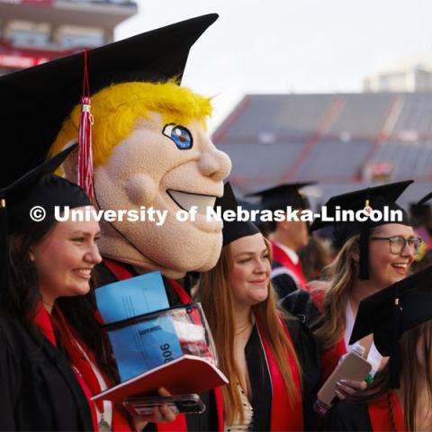 Herbie Husker poses with fellow graduates Saturday morning. Undergraduate Commencement in Memorial Stadium. May 18, 2024. Photo by Craig Chandler / University Communication and Marketing.
