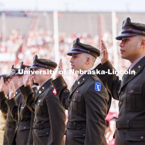 Nineteen ROTC cadets including Army Second Lieutenant Daniel Do of Lincoln recite their commissioning oath in front of the commencement stage. The actual military and naval commissions have been done over the past couple of days, but the group repeated their oath for the ceremony. Undergraduate Commencement in Memorial Stadium. May 18, 2024. Photo by Craig Chandler / University Communication and Marketing.