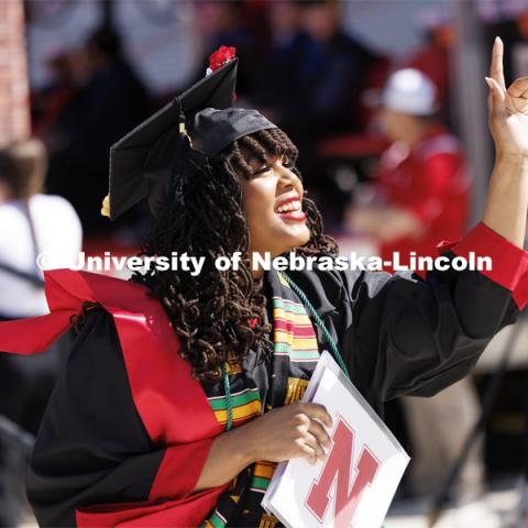 Divyn Williams waves to family and friends after receiving her degree from the College of Business. Undergraduate Commencement in Memorial Stadium. May 18, 2024. Photo by Craig Chandler / University Communication and Marketing.