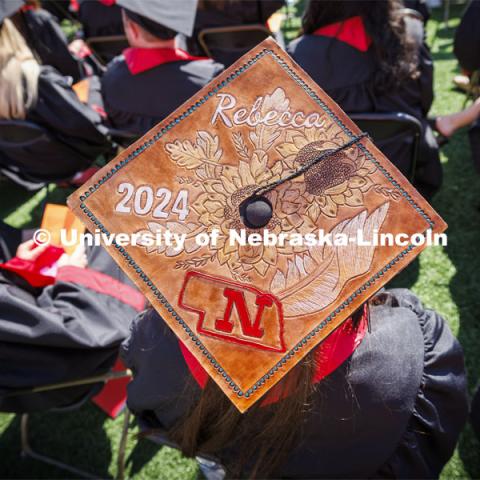Rebecca Wulf wore a mortar board decorated with embossed leather. Undergraduate Commencement in Memorial Stadium. May 18, 2024. Photo by Craig Chandler / University Communication and Marketing.