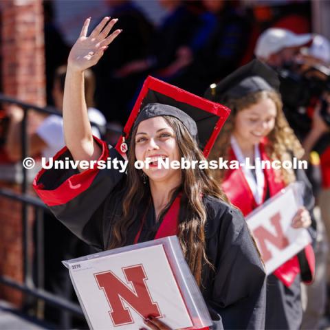 Breanna Glover waves to family and friends after receiving her diploma. Undergraduate Commencement in Memorial Stadium. May 18, 2024. Photo by Craig Chandler / University Communication and Marketing.