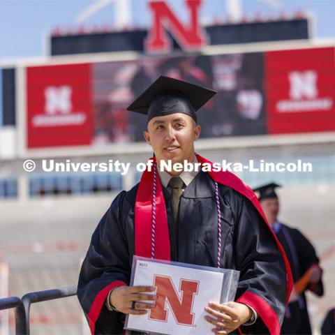 Daniel Do, an Economics major in the College of Arts and Sciences and an US Army second lieutenant after being in the UNL ROTC program, walks off the stage. Undergraduate Commencement in Memorial Stadium. May 18, 2024. Photo by Craig Chandler / University Communication and Marketing.