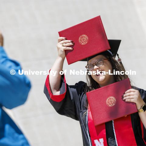 Maggie Nielsen, a Global Studies and Advertising Public Relations double major, mugs for a photo while holding her two diplomas following commencement. Undergraduate Commencement in Memorial Stadium. May 18, 2024. Photo by Craig Chandler / University Communication and Marketing.