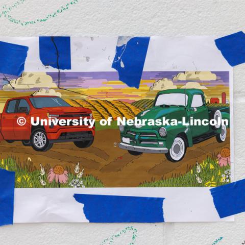 A printout of what the mural is supposed to look like it taped to the wall for reference. ARTS 398 - Special Topics in Studio Art III taught by Sandra Williams. The class painted a mural at the Premier Buick, Chevrolet, and GMC dealership in Beatrice. June 3, 2024. Photo by Craig Chandler / University Communication and Marketing.