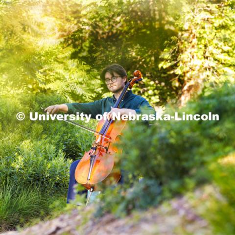 Connor Peterson, a senior in music, plays his cello in the greenspace between Love Library and Hamilton Hall while being filmed for a student spotlight by the Glenn Korff School of Music. June 5, 2024. Photo by Craig Chandler / University Communication and Marketing.