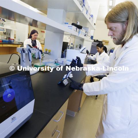 Flow Cytometry Service Center Manager Dirk Anderson works in the Flow Cytometry lab in the Morrison Center along with Kassandra Durazo-Martinez, left, and Sushmita Kumari, rear center. Nebraska Center for Biotechnology. June 13, 2024. Photo by Craig Chandler / University Communication and Marketing.