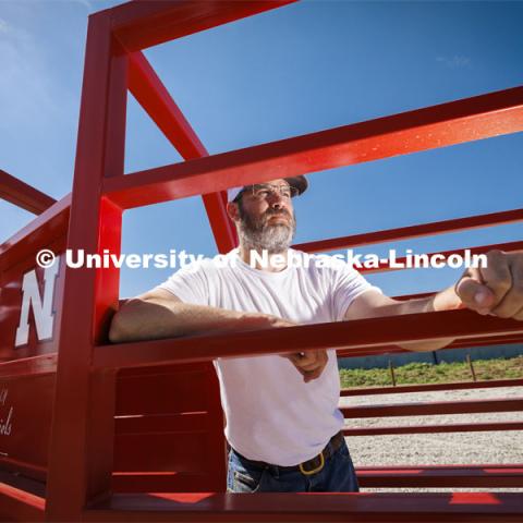 Josh Benton, beef feedlot unit director, poses inside the alleyway. The handling equipment at the new center was donated by Daniels Manufacturing Company of Ainsworth, Nebraska. Feedlot Innovation Center at the Eastern Nebraska Research, Extension and Education Center (ENREEC) near Mead, Nebraska. June 21, 2024. Photo by Craig Chandler / University Communication and Marketing.