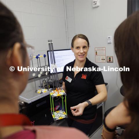 Christine Wittich, Assistant Professor in Civil and Environmental Engineering, explains why the pointed top of the building designed by Moe McCall, center, and Bella Thomas did better than the building without a top. Sovereign Native Youth STEM Leadership Academy sponsored by MATC. June 24, 2024. Photo by Craig Chandler / University Communication and Marketing.