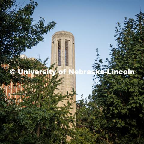 Mueller Bell Tower on city campus is framed by trees. On campus filming. Behind the scenes photo for the university's new "Home Again" national advertisement. June 25, 2024. Photo by Kristen Labadie / University Communication.   