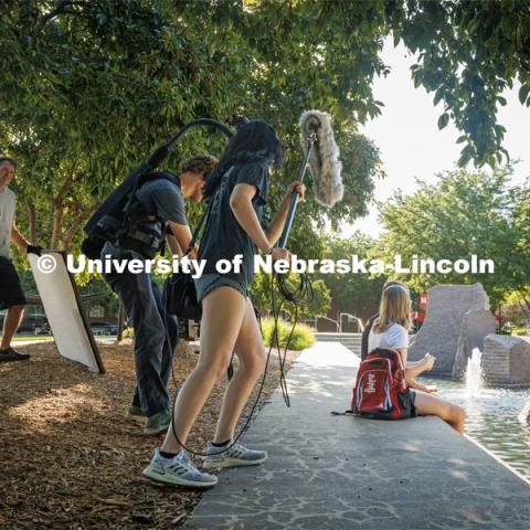 A film crew records students relaxing by Broyhill Fountain. On campus filming. Behind the scenes photo for the university's new "Home Again" national advertisement. June 25, 2024. Photo by Kristen Labadie / University Communication.   