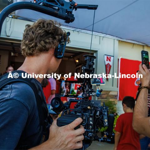 A film crew records a garage husker watch party in Omaha. Behind the scenes photo for the university's new "Home Again" national advertisement. June 26, 2024. Photo by Kristen Labadie / University Communication.   