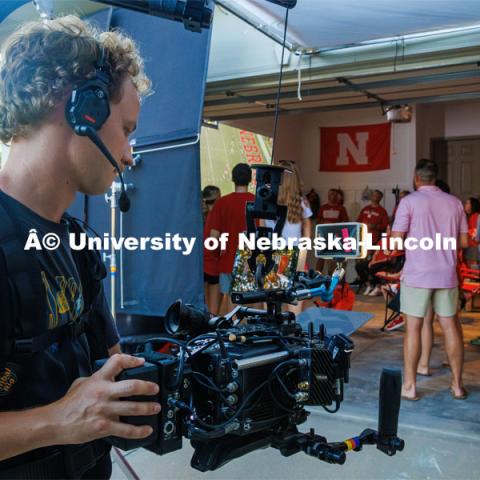 A film crew records a garage husker watch party in Omaha. Behind the scenes photo for the university's new "Home Again" national advertisement. June 26, 2024. Photo by Kristen Labadie / University Communication.   