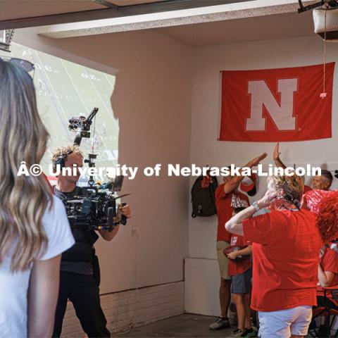 A film crew records a garage husker watch party in Omaha. Behind the scenes photo for the university's new "Home Again" national advertisement. June 26, 2024. Photo by Kristen Labadie / University Communication.   