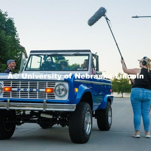 A film crew records a garage husker watch party in Omaha. Behind the scenes photo for the university's new "Home Again" national advertisement. June 26, 2024. Photo by Kristen Labadie / University Communication.   