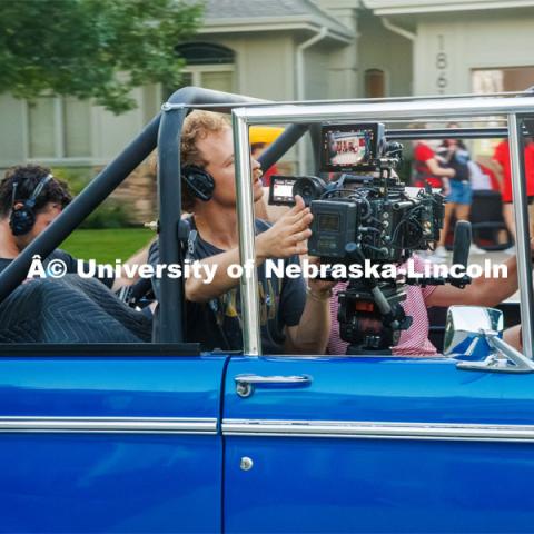 A film crew records a garage husker watch party in Omaha. Behind the scenes photo for the university's new "Home Again" national advertisement. June 26, 2024. Photo by Kristen Labadie / University Communication.   