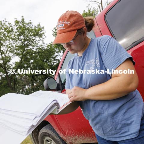 Shelby Kittle looks over the list of hives to be harvested for the day. Kittle, research technician and graduate student in entomology, removes frames from beehive on east campus. Hives are checked as sections of the hive are brought to the lab when they are full of honey. The UNL Bee Lab team monitors hives at multiple locations, harvesting the honey to use for education and as a fundraiser. June 27, 2024. Photo by Craig Chandler / University Communication and Marketing.