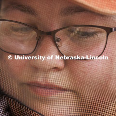 Shelby Kittle investigates a hive to check if the honey is ready to be harvested. Kittle, research technician and graduate student in entomology, removes frames from beehive on east campus. Hives are checked as sections of the hive are brought to the lab when they are full of honey. The UNL Bee Lab team monitors hives at multiple locations, harvesting the honey to use for education and as a fundraiser. June 27, 2024. Photo by Craig Chandler / University Communication and Marketing.