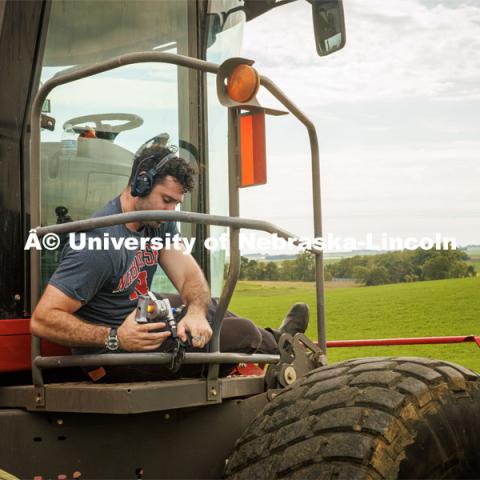 Filming a tractor in the field. Farming scenes. Behind the scenes photo for the university's new "Home Again" national advertisement. June 26, 2024. Photo by Kristen Labadie / University Communication.   