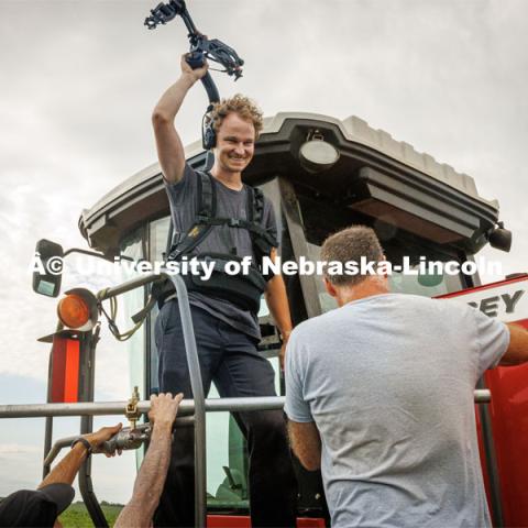 Filming a tractor in the field. Farming scenes. Behind the scenes photo for the university's new "Home Again" national advertisement. June 26, 2024. Photo by Kristen Labadie / University Communication.   