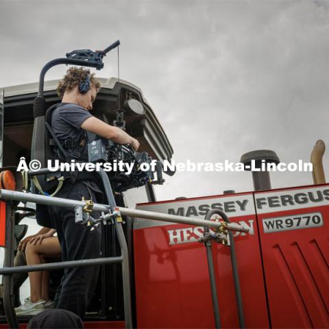 Filming a tractor in the field. Farming scenes. Behind the scenes photo for the university's new "Home Again" national advertisement. June 26, 2024. Photo by Kristen Labadie / University Communication.   