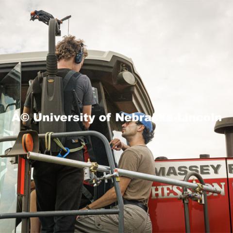 Filming a tractor in the field. Farming scenes. Behind the scenes photo for the university's new "Home Again" national advertisement. June 26, 2024. Photo by Kristen Labadie / University Communication.   