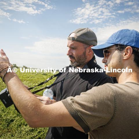 Filming a tractor in the field. Farming scenes. Behind the scenes photo for the university's new "Home Again" national advertisement. June 26, 2024. Photo by Kristen Labadie / University Communication.   