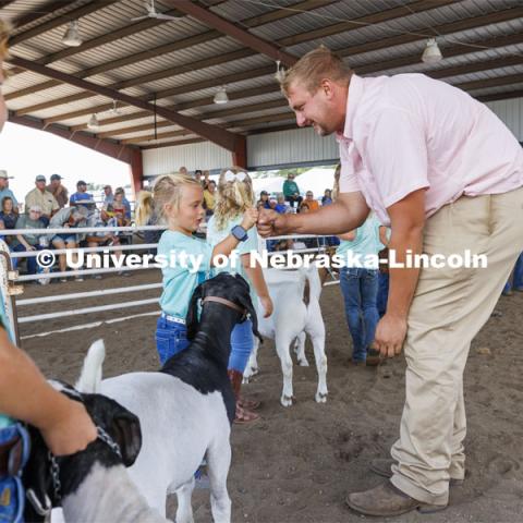 Goat judge John Alfs fist bumps with Ivy Mentink, 5, during Clover Kid competition. 4-H Polk County Fair in Osceola, Nebraska. July 19, 2024. Photo by Craig Chandler / University Communication and Marketing.
