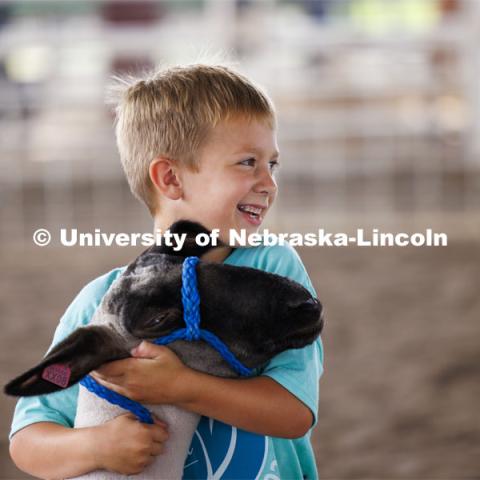 A young boy hugs his sheep. 4-H Polk County Fair in Osceola, Nebraska. July 19, 2024. Photo by Craig Chandler / University Communication and Marketing.