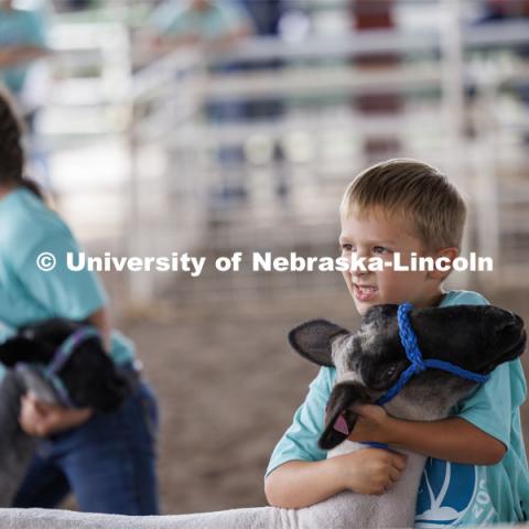 A young boy hugs his sheep. 4-H Polk County Fair in Osceola, Nebraska. July 19, 2024. Photo by Craig Chandler / University Communication and Marketing.